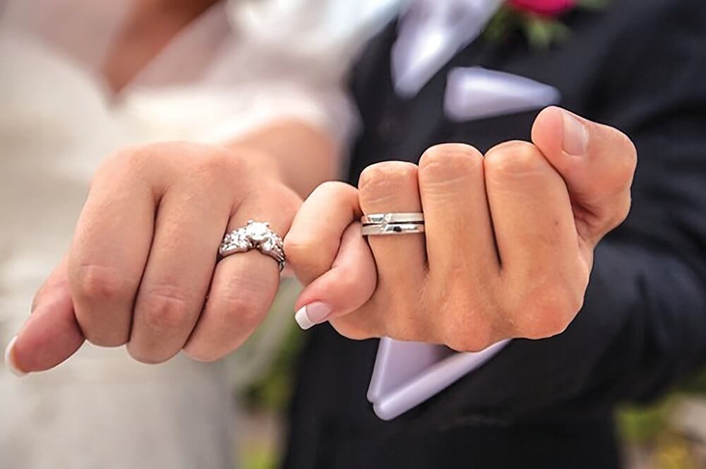 Couple holding hands with rings